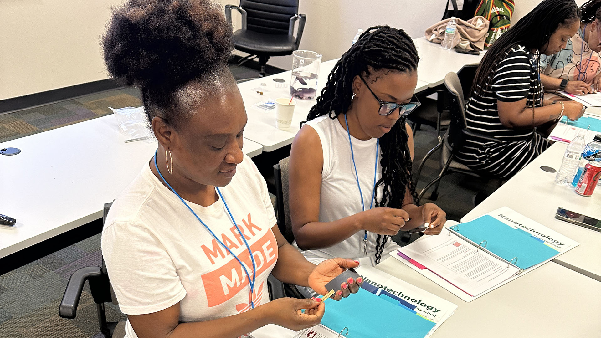 Two teachers learning about magnetic fields during a summer workshop